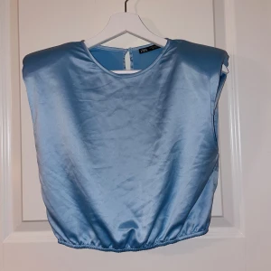 Babyblå silke topp - Kortärmad babyblå / pastell blå crop top som är fårn Zara. Används en gång. Inga skador eller fläckar. 