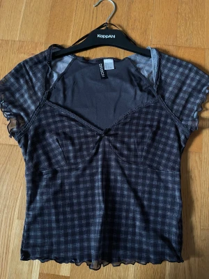 Supersöt Svart Topp - Så himla gullig svart rutig topp med rosett som tyvärr inte passade mig 🥺Helt ny och därav oanvänd!