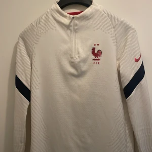 Frankrike träningströja  - Detta är frankrikes träningströja. Den är helt ny och nästan oanvänd. Den är i helt bra skick. Jag säljer den eftersom den är tajt på mig. Jag köpte den för 750 kr i nike butiken. Perfekt för sommaren.