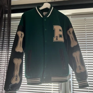 Collegejacka  - Jätte fin grön svart college jacka med hundben på armarna⭐️ använd en gång då den är för stor på mig💞 köparen står för frakt!