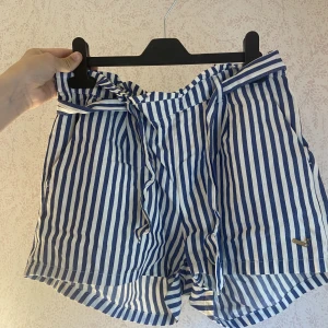 Shorts - Ett par randiga blå vita shorts,storlek 170.40kr + 25kr frakt, guld märket är lite sönder 