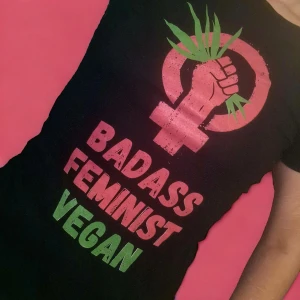 T-shirt med tryck BADASS FEMINIST VEGAN - Supercool t-shirt med kvinnotecken och texten "Badass feminist vegan". Fint skick! Storlek S, men stretchig (passar XS-M) Använd gärna köp-knappen 💖💖💖