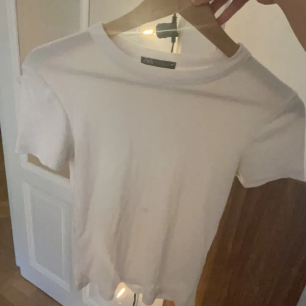 En jötte gullig vit T-shirt från zara. Har en liten fläck på framsidan av tröjan men annars än det är den i toppskick💗 säljer pga att den inte kommer till användning!. T-shirts.