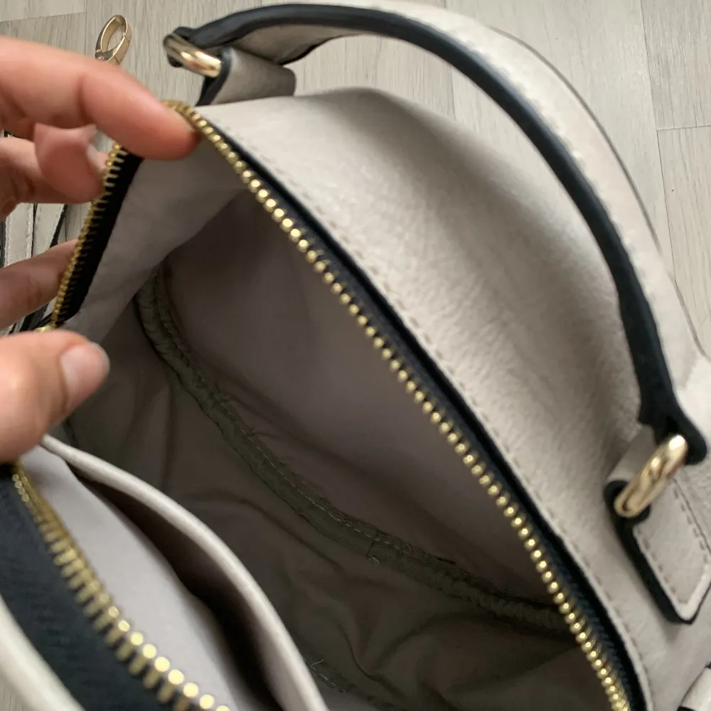 Handväska aldrig använd, från Xti man får med axelbandet men har oxå handtag på väskan. Har en mini ficka i💕 färg beige/vit med tryck väskan. Väskor.
