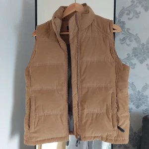 Dunväst i mocks imitation  - Dunväst från Musto sparsamt använd strl 12 skulle säga att den är en D