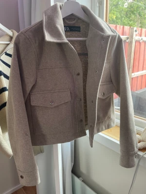 Zara jacka - Jag säljer jackan då den inte används så mycket längre den är beige med silvriga detaljer. Den är använd en höst men det syns knappt.