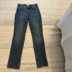 Säljer nu dessa mörkblåa straight jeans från zara, de har en liten slits ned till och är midwaist. De är aldrig använda så nyskick. Fin färg till hösten.