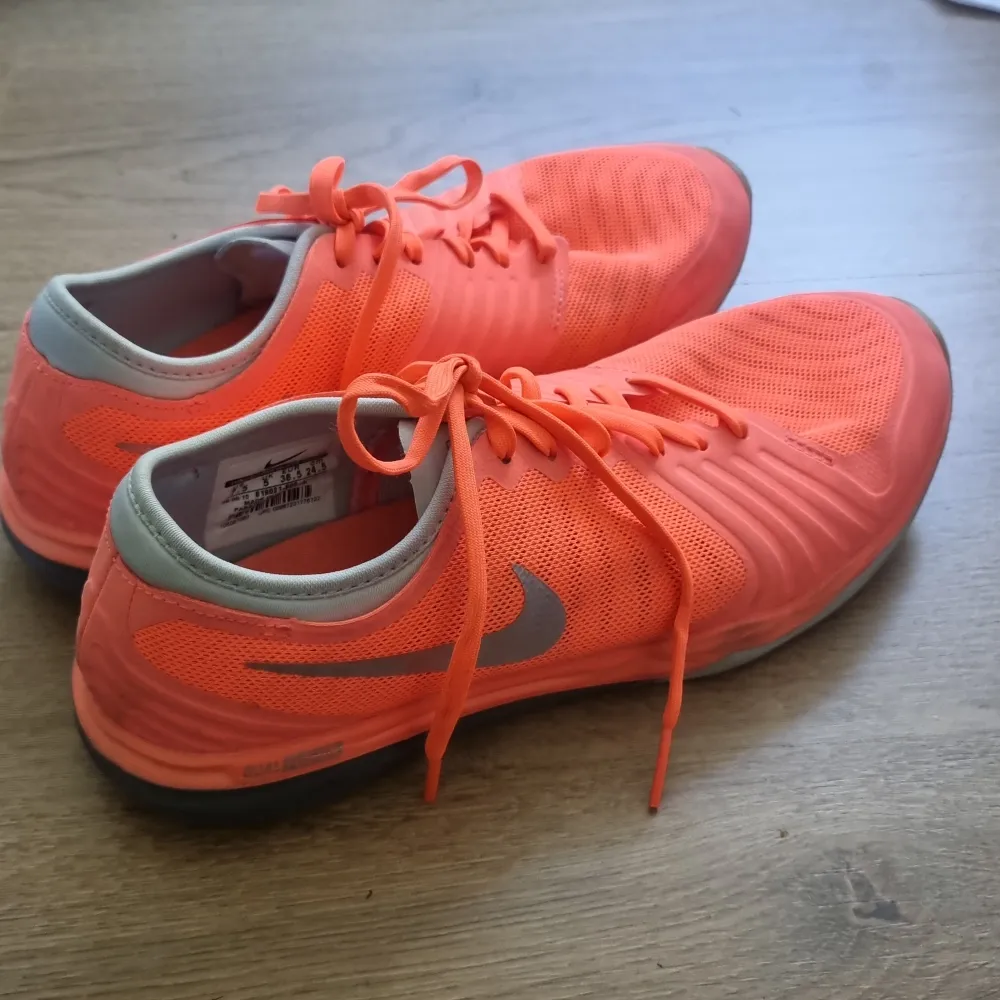 Träningsskor från nike, i en orange/korallfärg. Använd några få ggr, fint skick!! Strl 38,5.. Skor.