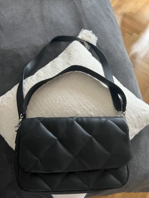 Axelväska  - Axelremsväska med två band i olika lägen.   Använd en gång 