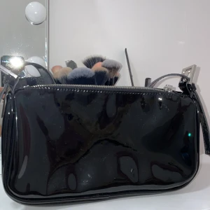 Svart lack väska - Jätte fin axelväska som jag fick i present som kommer inte till användning längre. Köpt på Gina tricot. För mer frågor och bilder kontaktas mig.