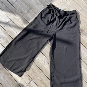 Vida trekvartsbyxor - Svarta trekvartsbyxor, ganska tjockt tyg, mjukt och följsamt material. Lång, justerbar snörning i midjan och rymliga fickor 
