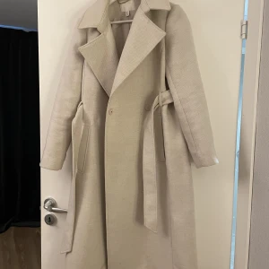 Lång kappa,  - Lång beige kappa. 