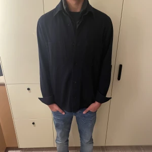 Mörkblå overshirt  - Säljer denna feta mörkblåa overshirt från arket. Skicket är 9/10 då den inte är använd så mycket. Nypris 700kr
