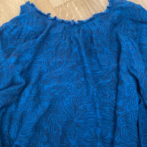 Blus  - Mörkt blå  med svart mönster. Nästan oanvänd. Strl 38, men krympt i tvätten så motsvarar ca 36.