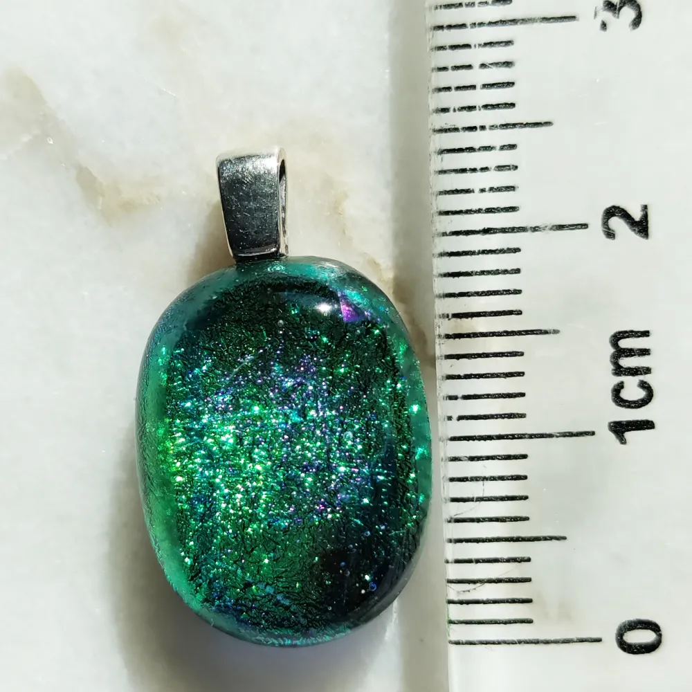 Hängsmycke i grönskimrande glas, silverpläterat hänge. Glaspärlan mäter ca 2 cm. Kedjan (Sterlingsilver 925) kan köpas separat.. Accessoarer.