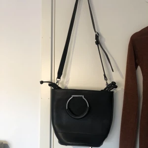 Väska  - Säljer denna svarta handväskan från Carin Wester som jag fått men inte kommer till användning. Väskan är så gott som nyskick och har knappt används 