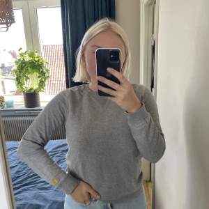 Carhartt Sweatshirt  - Grå sweatshirt från Carhartt i storlek S (dam). Säljer då den är förliten för mig, har M vanligtvis! Bara använd ett fåtal gånger och i bra skick 😍 Köparen står för frakten! 