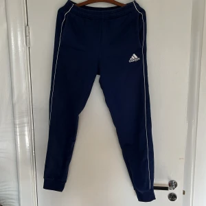 Adidas byxor blåa - Blåa adidas mjukis/träningsbyxor med framfickor. Knappt använda, därmed i mycket fint skick. Tveka inte på att skicka DM vid frågor.