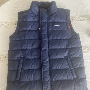 Gant Väst 158/164 - Gant väst i nyskick. Inköpt för cirka 2 år sedan men är knappt använd. Inga synliga defekter. Skall passa 13-14 år (158/164cm)