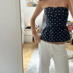 Mörkblå prickig bandeutopp korsetttopp - Skitsnygg bandeutopp med korsettliknande överdel! Strl m men skulle säga att den sitter mer som en s!