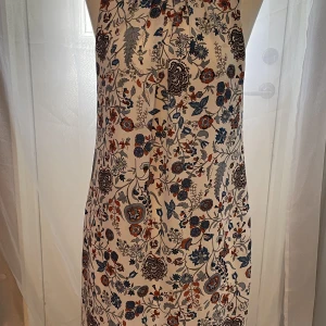 Blommig klänning  - Knyt i ryggen och typ öppen rygg.