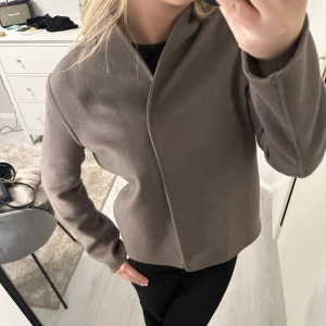 Wera jacka - Säljer min korta kappa från wera/Åhléns. Jättesnygg och NYSKICK. Knappt använd och nypris är 1500kr. Färgen är kall beige/brun