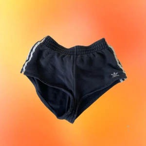 Adidas-shorts - Ett par adidasshorts som har en retro känsla. Vill man ha de högmidjat sitter de som ”booty shorts” medan som lågmidjat sitter de som vanligt. Använda med i gott skick! Vid högt intresse gäller budgivning annars först till kvarn! +29kr frakt