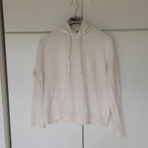 Vit hoodie - Vit hoodie från Lager 157 i storlek XS. Cirka 55 cm från axeln ner till slutet av midjan. Armlängd från armhålan är 42 cm. 