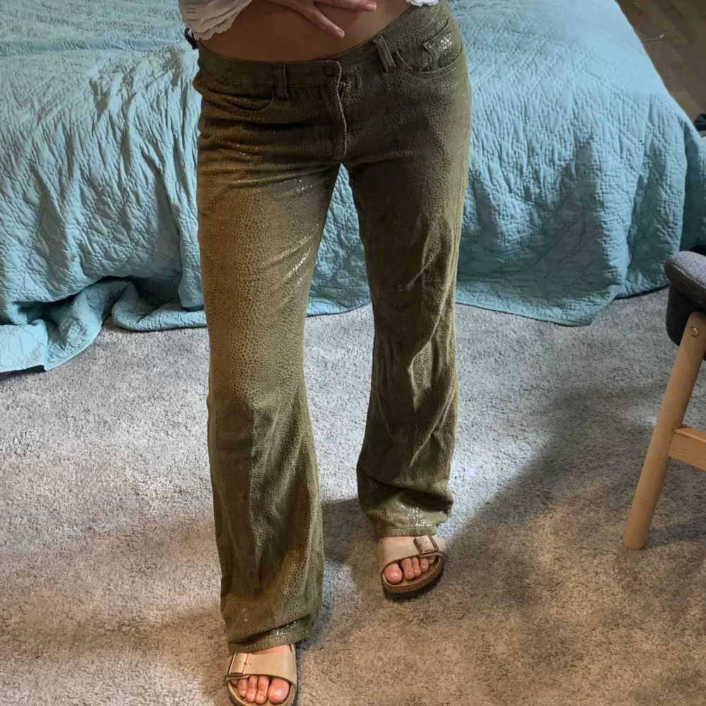 Gröna byxor i coolt ”ormskinn” liknande material. Jag är 167, de sitter lågmidjat på mig som brukar ha 36 i byxor.. Jeans & Byxor.
