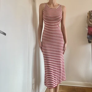 Stickad randig klänning - Skön och jättefin stickad maxidress med röda, beige och bruna ränder. Passar storlek S 🧶