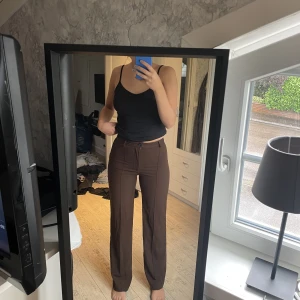 Bruna kostymbyxor - Säljer mina bruna kostymbyxor från Pull&Bear. Byxorna är i ett väldigt fint skick. 