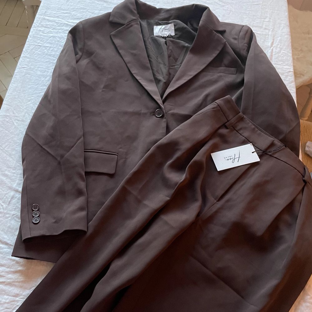Set med blazer och kostymbyxor från NAKD, Hoss kollektion. Fin mörkbrun färg🤎strl 38 i blazern och 36 i byxorna. Det är i superskick, aldrig använt!. Kostymer.