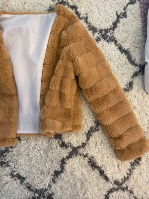 Jacka  - En pälsjacka. (Fake) ganska tunn inuti. 