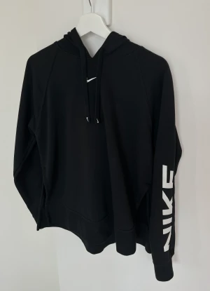Nike hoodie tjocktröja - Svart hoodie från NIKE, storlek S. Knappt använd, jättefint skick.  Vit Logga på ena ärmen och små ”slits” var sida (se bild 3).