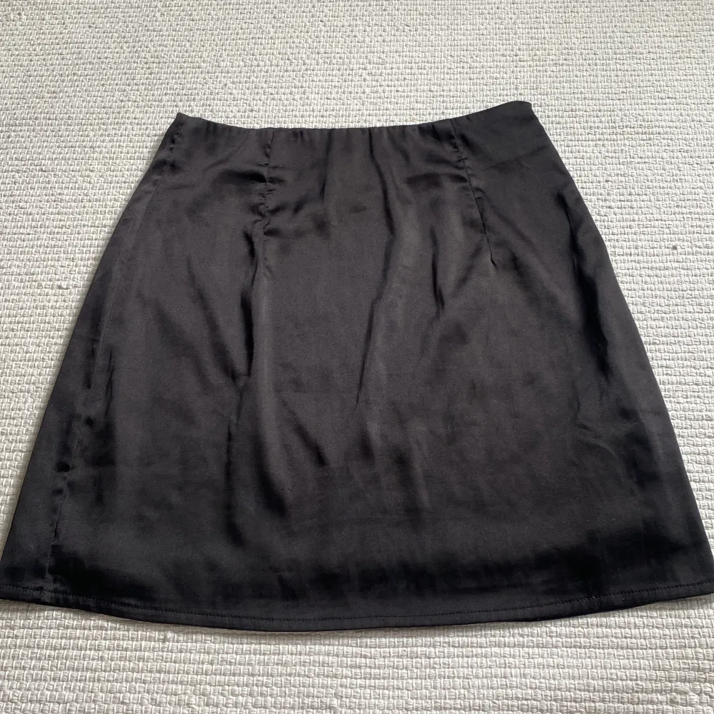 Svart kjol i silkesmaterial, från missguided men köpt på nellys hemsida. Storlek 34, passar Xs/S💕 Fint skick, köparen står för frakt! . Kjolar.