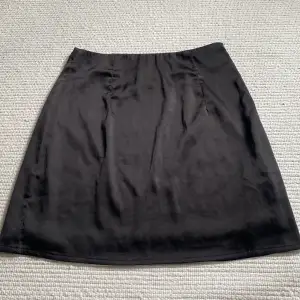Svart kjol i silkesmaterial, från missguided men köpt på nellys hemsida. Storlek 34, passar Xs/S💕 Fint skick, köparen står för frakt! 