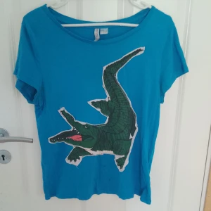 Krokodil tshirt  - Har sytt på krokodilen själv. Tshirten har tre små hål lite under krokodilen med anars är den i bra skick.