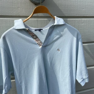 Burberry pike - Halloj, säljer nu min snygga burberry piké som är perfekt nu till sommaren. Knappt använd och därför inga tecken på användning, dvs inga slitningar eller fläckar nånstans. Skick 10/10. Storleken är S, men den sitter som M. 
