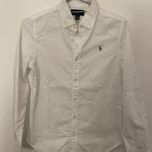 Vit skjorta  - Äkta Ralph Lauren skjorta i vit färg. Köpt på Kids Brandstore som säljer kläder för tonåringar. Storlek på denna skjorta är 16 vilket motsvarar XS. Den har inga defekter, och har endast använts en gång då den inte passar mig längre.