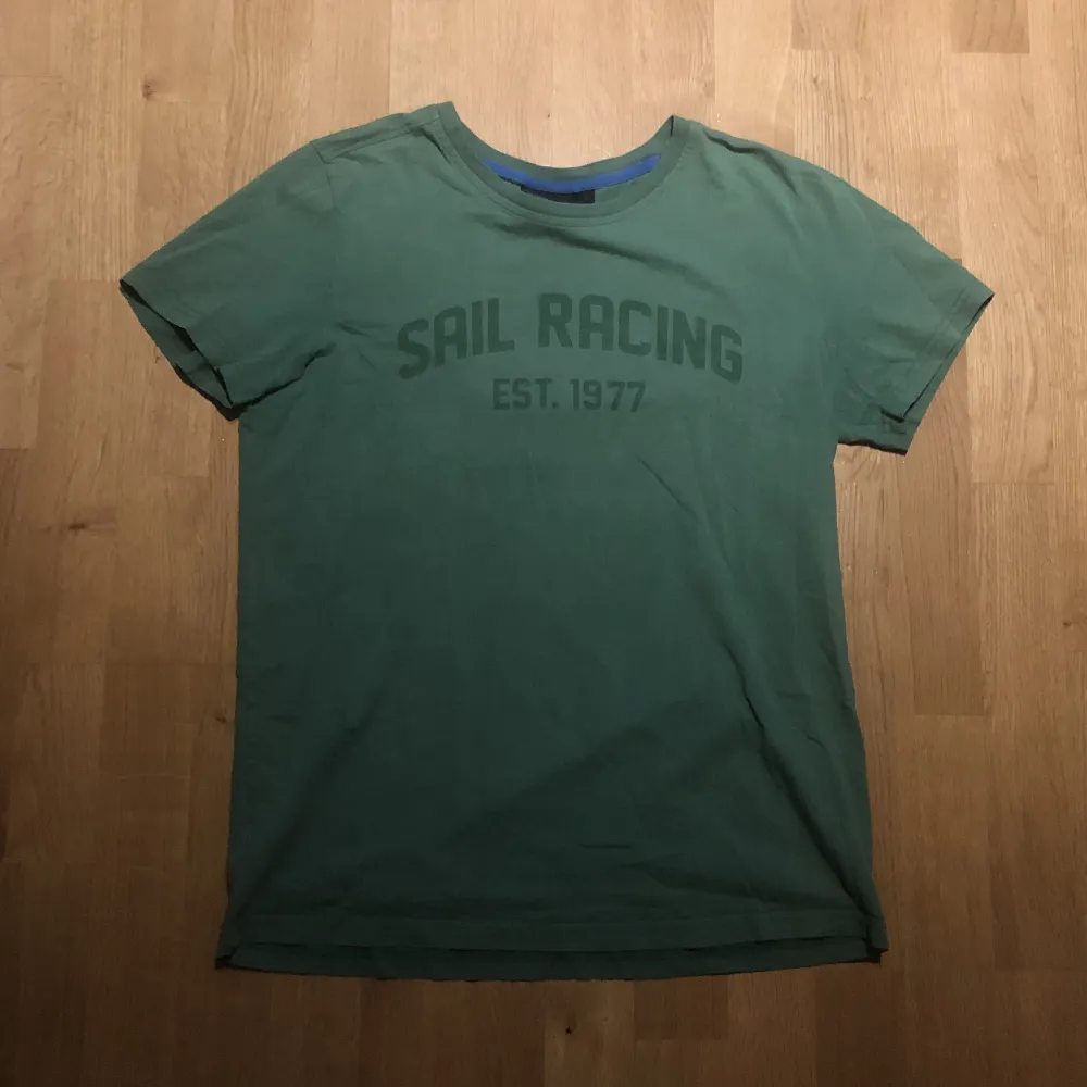 En väldigt snygg vintage t-shirt från märket Sail Racing! Själv tycker jag tröjan är i bra skick fortfarande och den har en skit snygg grön färg!! 🙏🤘samt fler detaljer så skriv om ni vill ha fler bilder eller frågor! . T-shirts.