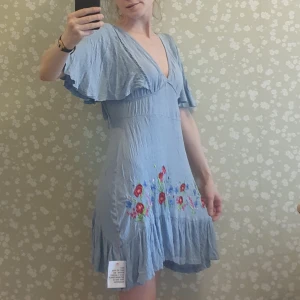 Blå sommarklänning med brodyr - Ljusblå luftig sommarklänning med broderade detaljer