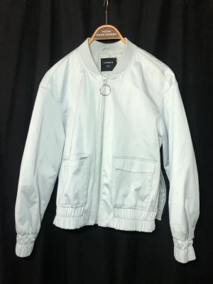 Jacka  - Enkel ljusgrå bomberjacka från Lindex. Dragkedjor på sidorna av jackan.