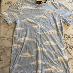 Blå simpsonströja - Tröja som är blå med moln på. Är inspirerad av the Simpsons 