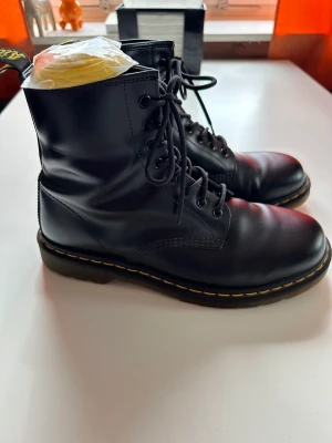 Dr Martens  - 8-håls kängor. Dr Martens Original.  Extremt välbehållna och sulan är ytterst lite sliten. 9,5/10 i skick.  Ingår även nya snören i gult som sig bör.