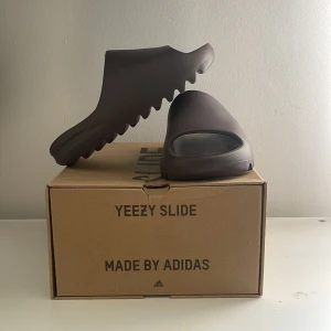 Yeezy slides i färgen Soot, oanvända i original box  - Yeezy slides som dessvärre aldrig kommit till användning då de är en aning små i storlek. Kommer med ordinarie box,   Stl 38a men mer som en 37a, de är självklart äkta köpta på stockX (se slide 2)  Kan mötas i Malmö annars står köparen för frakt 🫶🏽   