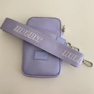 Pouch väska i färgen lavender  - Holdit Pouch väska i färgen lavender Orginal pris 499kr Skick: fint skick, använd vid 1 tillfälle. 