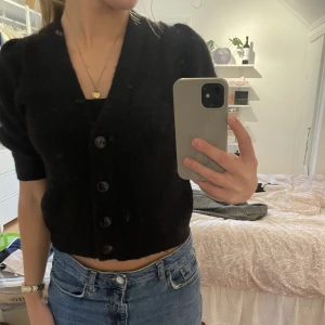 Svart stickad kofta monki  - Säljer en svart stickad kortärmad kofta från Monki. Köpt för ca 3 år sen men är aldrig använd. Koftan är i storlek xs. 