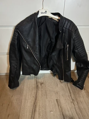 Svart skinnjacka  - Den är i storlek 40 men jag har S i kläder, den är liten i storlek. Inget dåligt på skicket