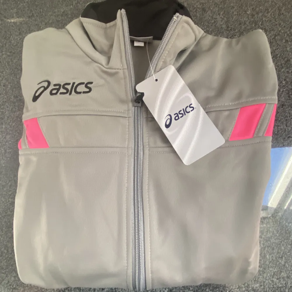 Helt ny/oanvänd zip-tröja från Asics. . Hoodies.