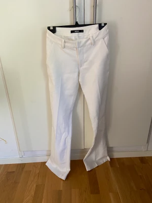 Kostymbyxor från Bokbok - Lågmidjade vita kostymbyxor från Bikbok i strl 34. Använda ett fåtal gånger. Säljer då dem blivit för små för mig!